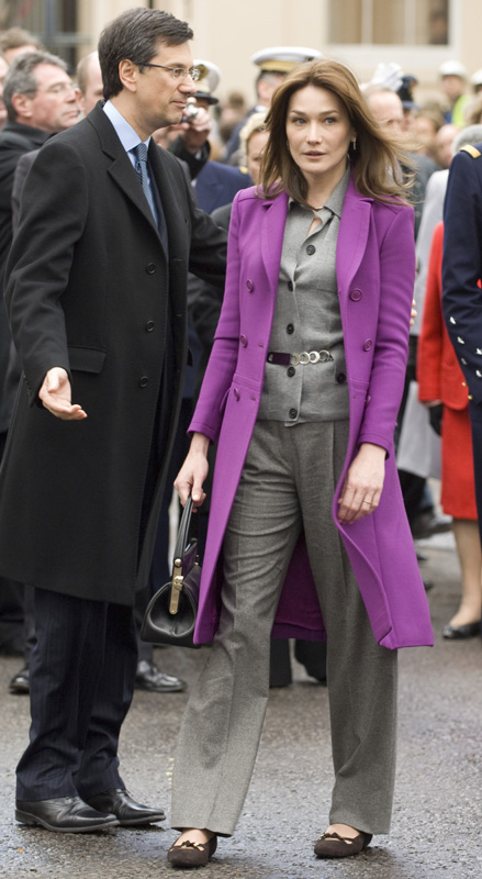 Карла Бруни в сиреневом пальто и сером брючном костюме