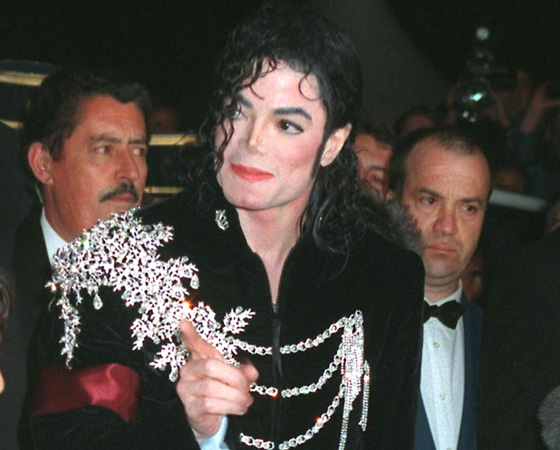 Певец Майкл Джексон в черном костюме с эполетами.